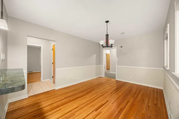 a view of a livingroom with wooden floor and a chandelier