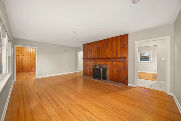 a view of an empty room with a fireplace and a window
