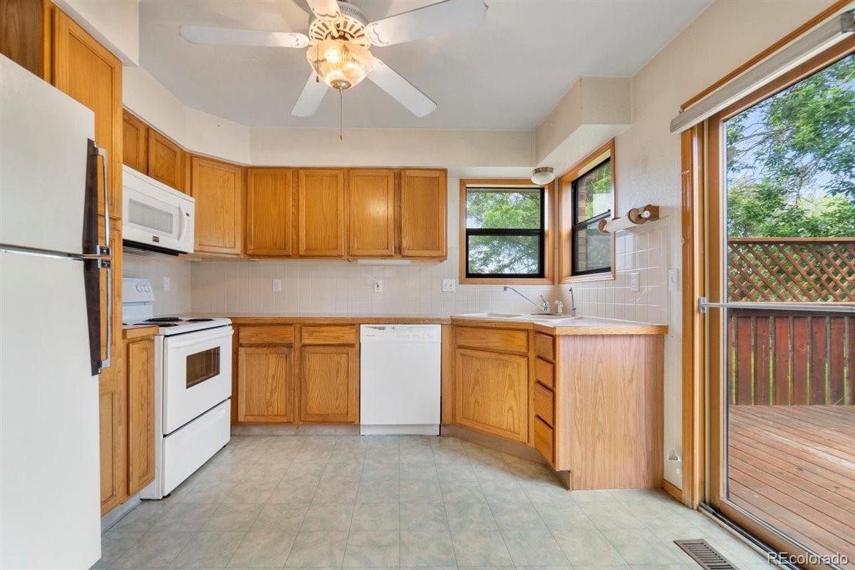 833 Wade Road Longmont, CO 80503 - Photo 14 of 40 a kitchen with stainless steel appliances granite countertop a stove a sink and a refrigerator