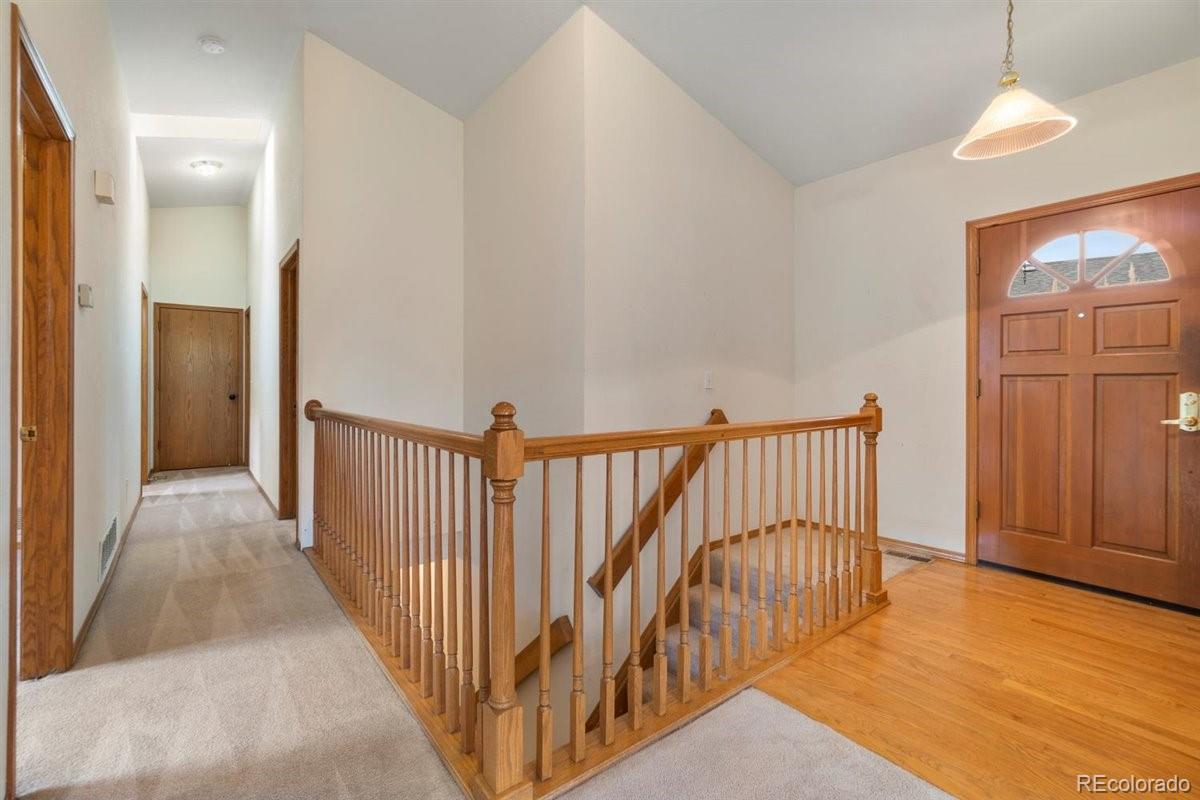 833 Wade Road Longmont, CO 80503 - Photo 17 of 40 a view of a hallway with wooden floor and windows