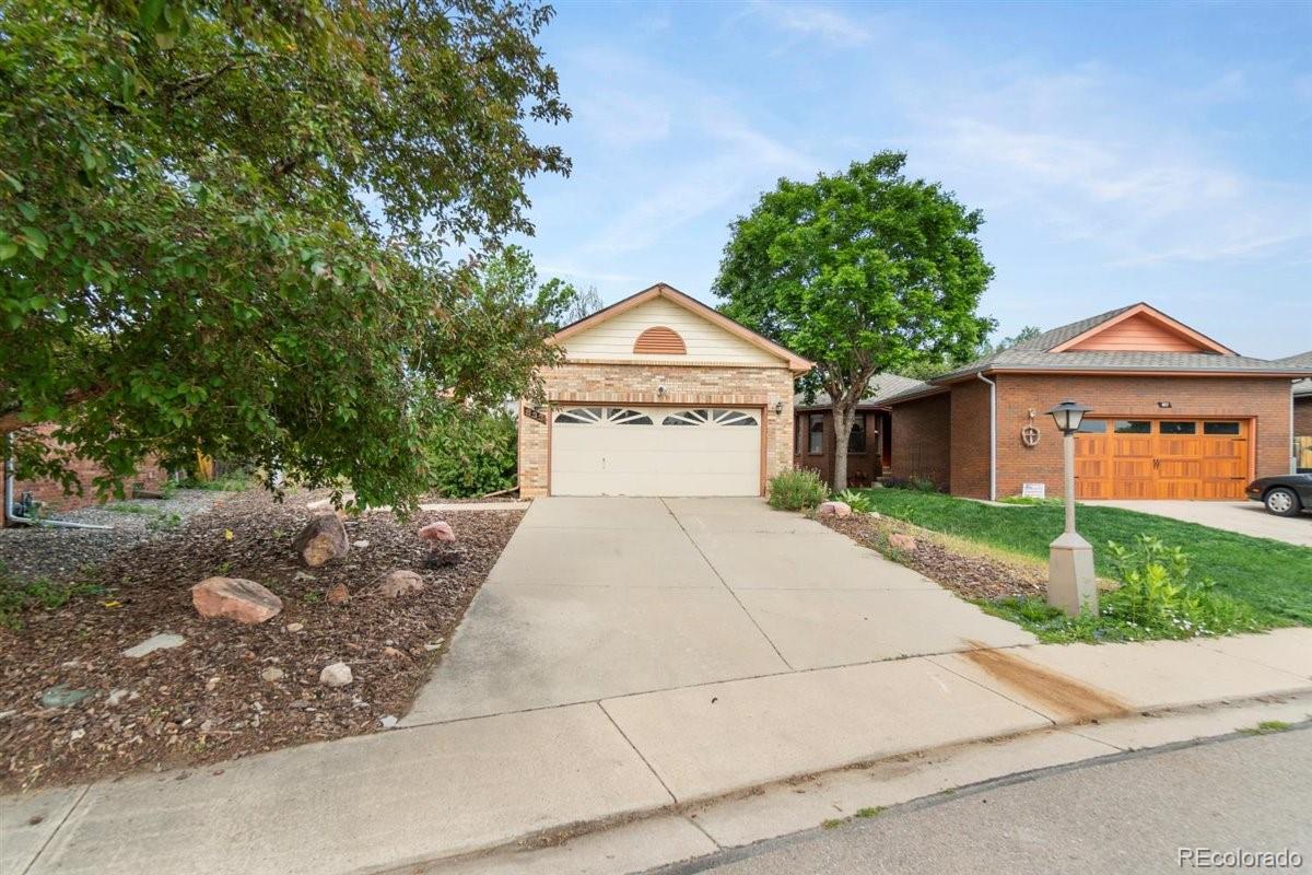 833 Wade Road Longmont, CO 80503 - Photo 3 of 40 a front view of a house with a yard and garage