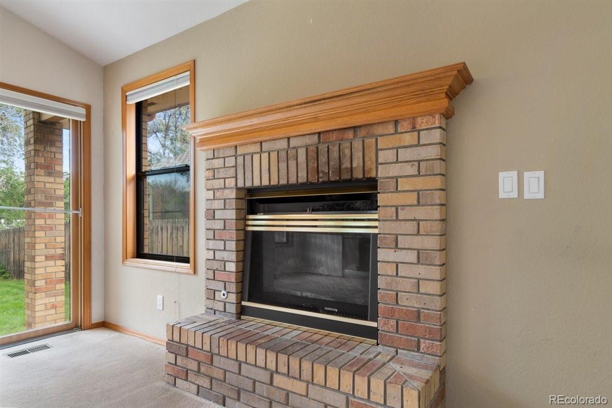 833 Wade Road Longmont, CO 80503 - Photo 10 of 40 a living room with a fireplace and a window