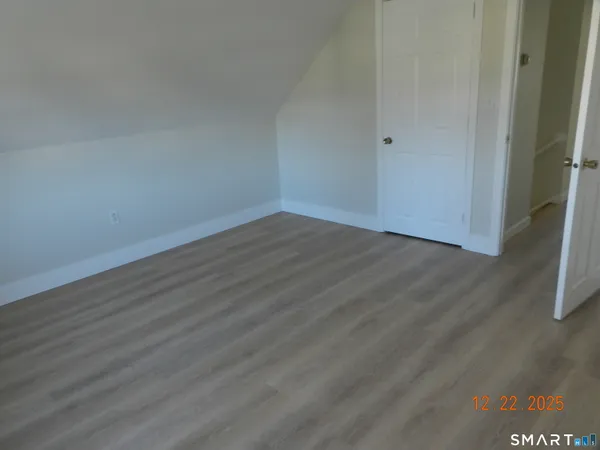 a view of an empty room with wooden floor