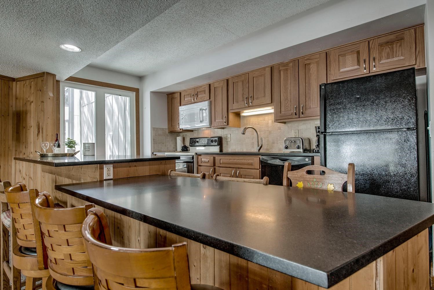 1075 Ski Hill Road, Unit 46 Breckenridge, CO 80424 - Photo 11 of 41 a kitchen with stainless steel appliances granite countertop a sink a stove and a refrigerator