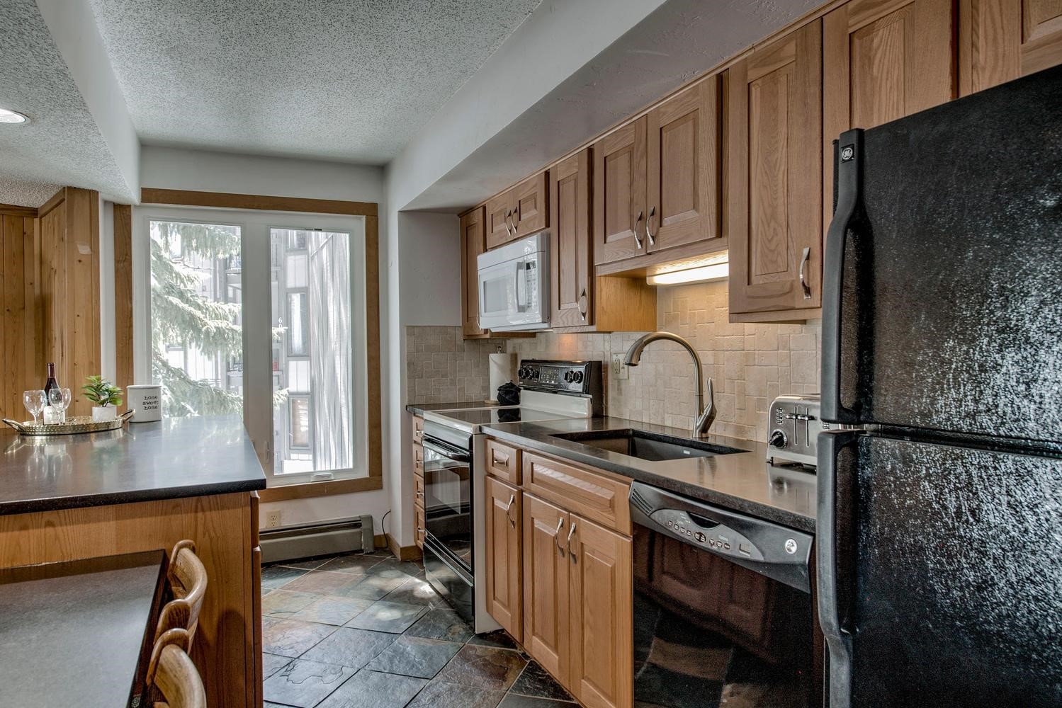 1075 Ski Hill Road, Unit 46 Breckenridge, CO 80424 - Photo 12 of 41 a kitchen with stainless steel appliances granite countertop a stove a sink dishwasher and a refrigerator