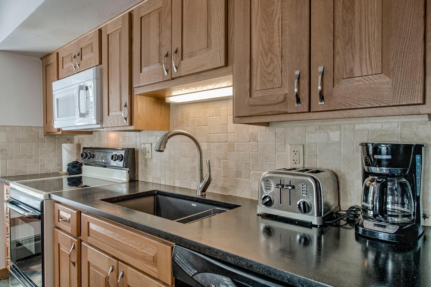 1075 Ski Hill Road, Unit 46 Breckenridge, CO 80424 - Photo 13 of 41 a kitchen with stainless steel appliances granite countertop a sink a stove and white cabinets