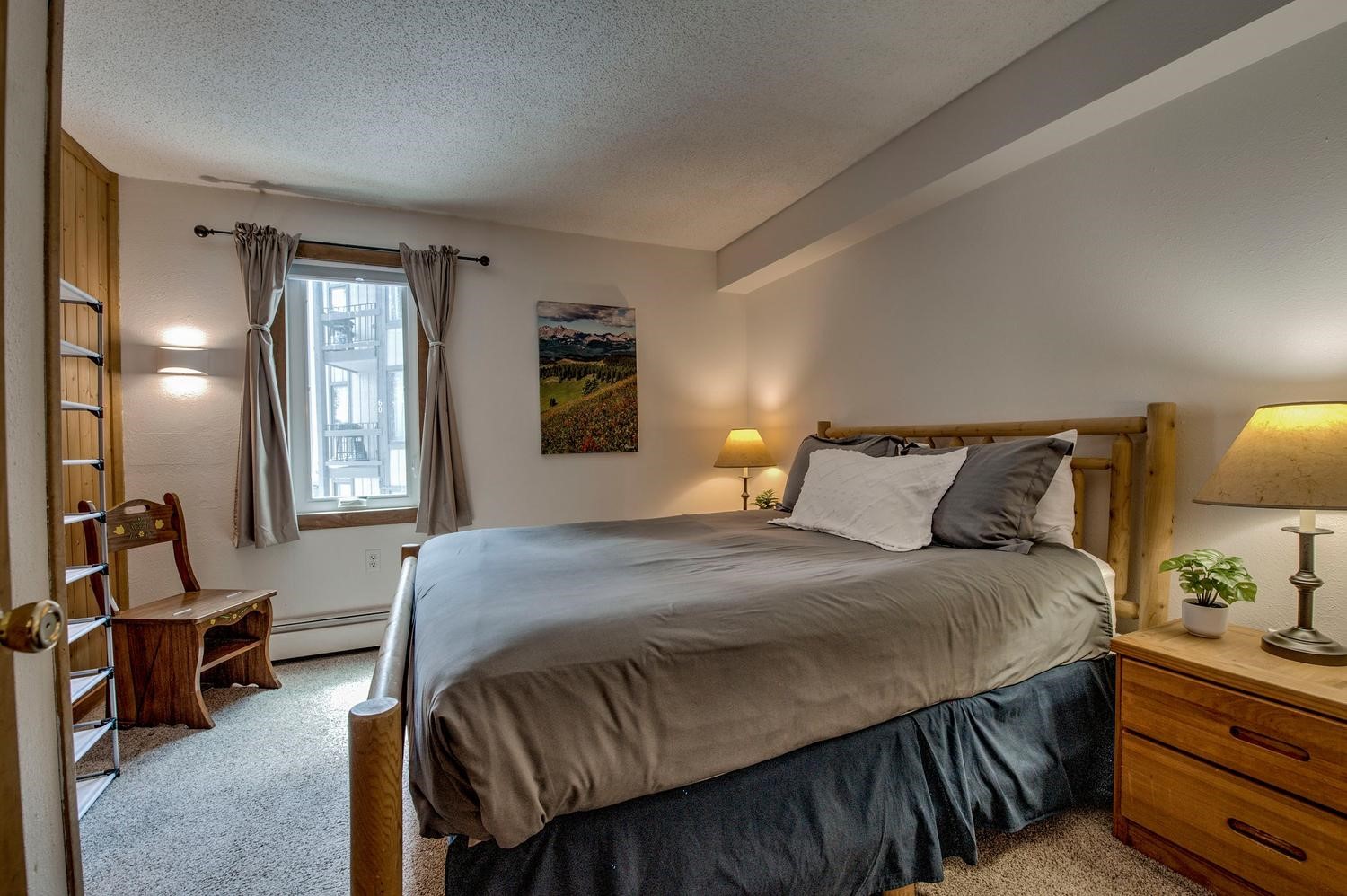 1075 Ski Hill Road, Unit 46 Breckenridge, CO 80424 - Photo 15 of 41 a bedroom with a bed a lamp and window