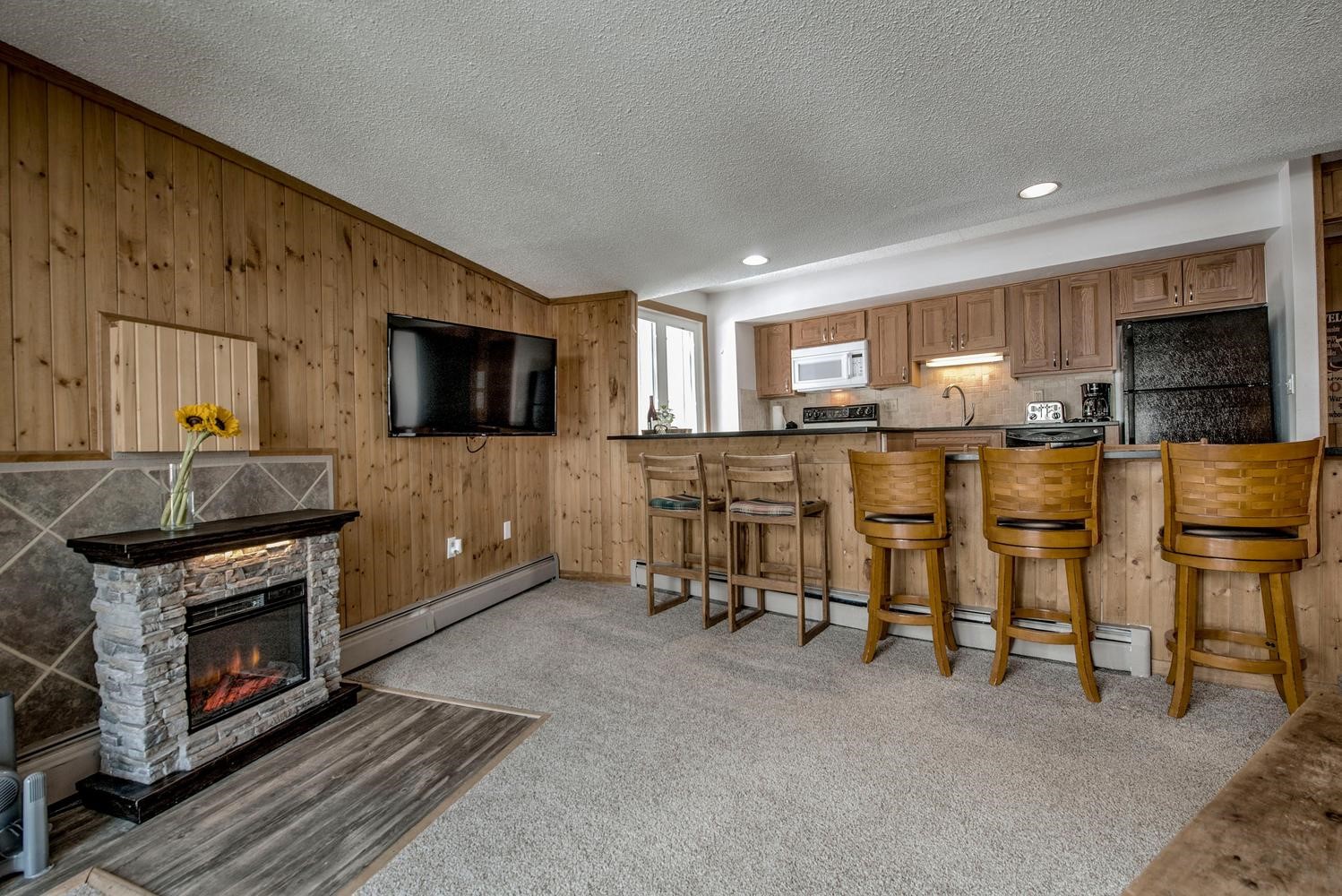 1075 Ski Hill Road, Unit 46 Breckenridge, CO 80424 - Photo 8 of 41 a living room with stainless steel appliances furniture a fireplace a flat screen tv and a window