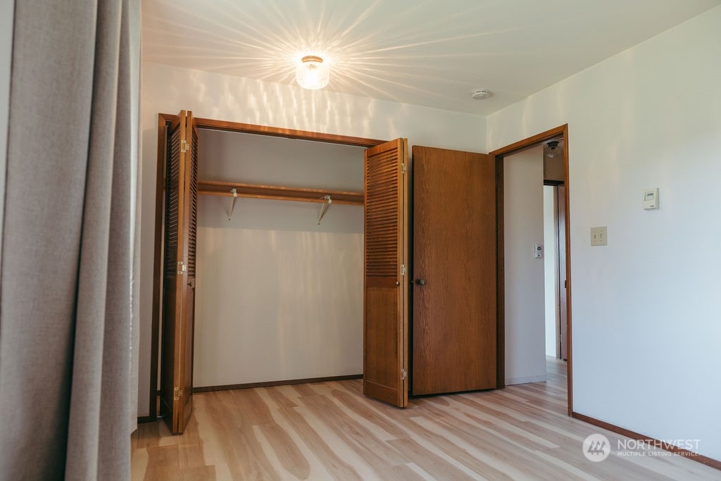 310 G Street Forks, WA 98331 - Photo 18 of 40 an empty room with wooden floor and a ceiling fan