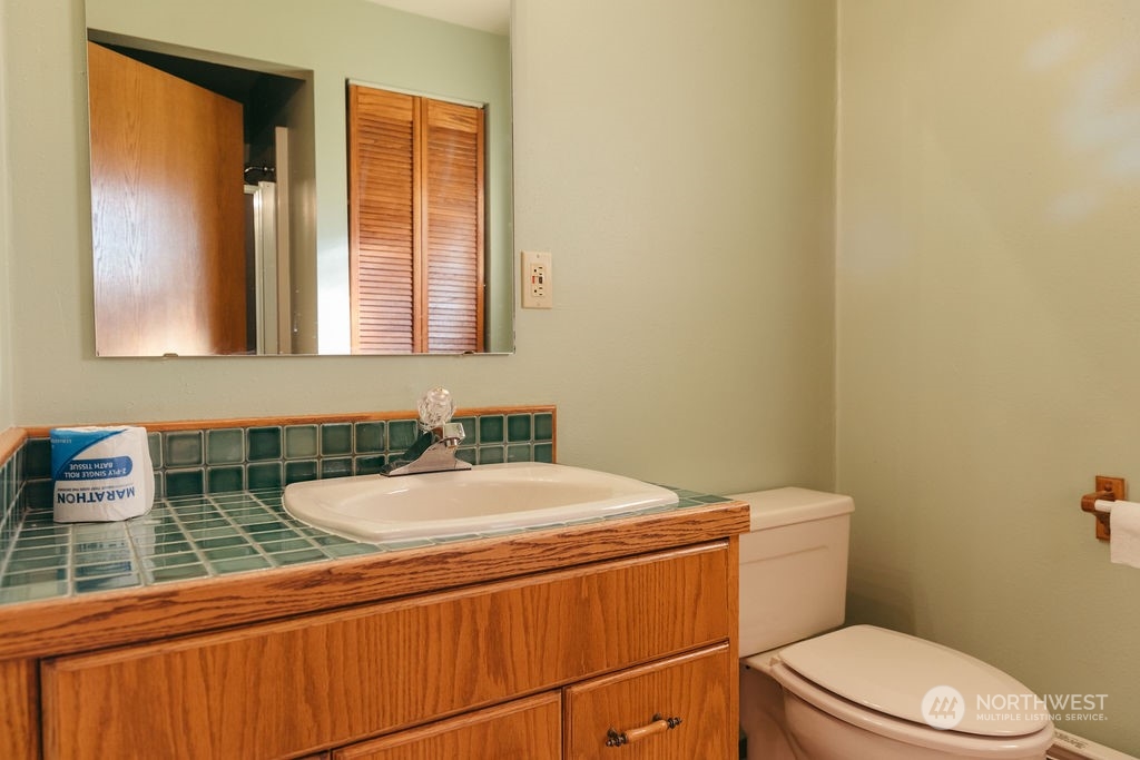 310 G Street Forks, WA 98331 - Photo 22 of 40 a bathroom with a sink a toilet and mirror