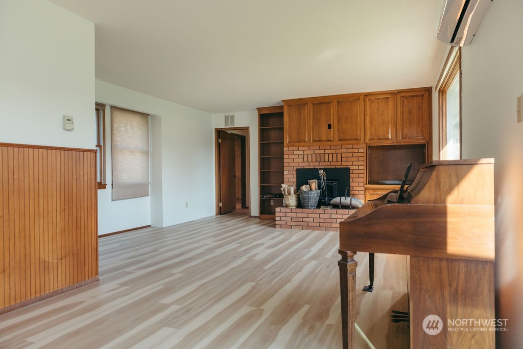310 G Street Forks, WA 98331 - Photo 8 of 40 an empty room with fireplace and wooden floor