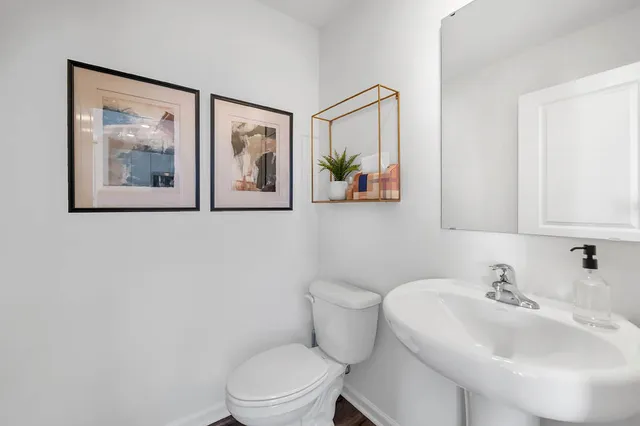 a bathroom with a toilet a sink and mirror