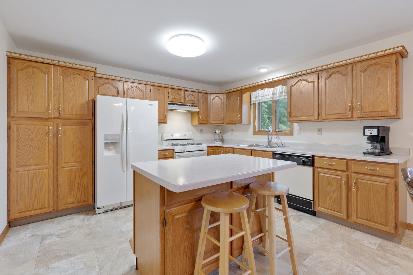 12402 Ridge Road Genoa, IL 60135 - Photo 10 of 31 a kitchen with stainless steel appliances granite countertop a sink a stove a refrigerator and cabinets