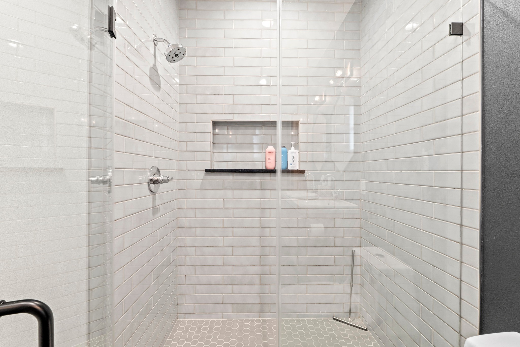 1706 Perez Street, Unit 2 Austin, TX 78721 - Photo 21 of 29 A sleek, contemporary shower with subway tile walls and a hexagonal tile floor offers a refreshing daily retreat.