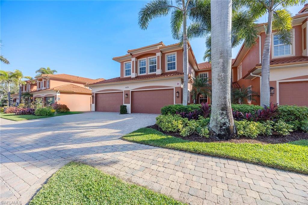 6438 Legacy Circle, Unit 301 Naples, FL 34113 - Photo 4 of 46 a front view of a house with a garden and plants