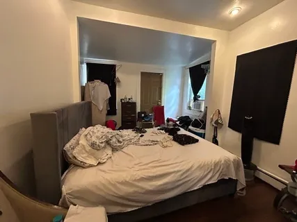 a bed sitting in a bedroom and flat screen tv