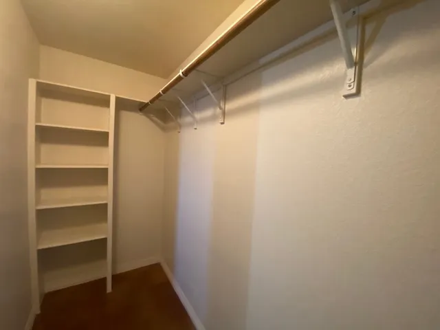 a view of walk in closet with empty racks