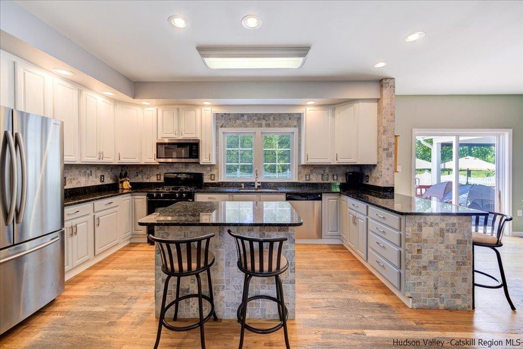 1237 Hoagerburgh Road Wallkill, NY 12589 - Photo 17 of 35 a kitchen with stainless steel appliances a table chairs sink refrigerator and cabinets