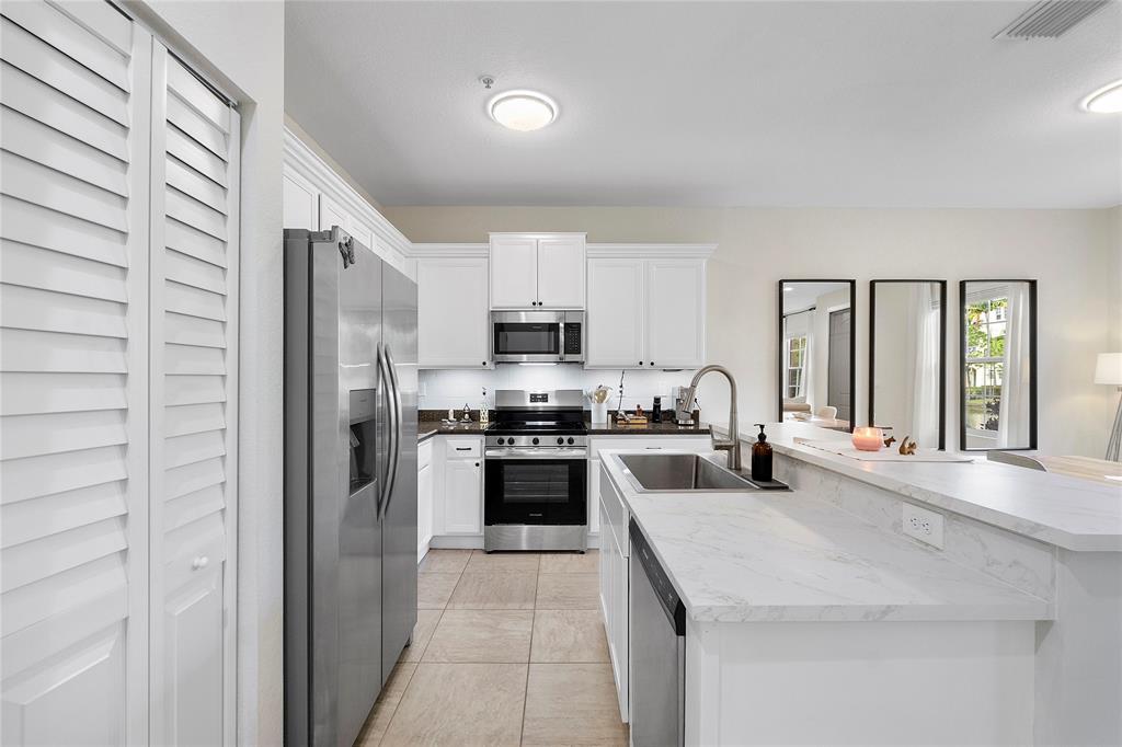 163 Southwest 7th Street Pompano Beach, FL 33060 - Photo 11 of 54 a kitchen with stainless steel appliances granite countertop a stove a sink and a refrigerator