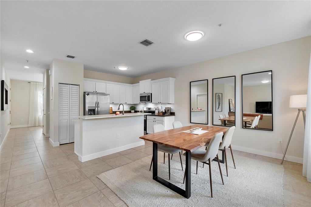 163 Southwest 7th Street Pompano Beach, FL 33060 - Photo 14 of 54 a kitchen with stainless steel appliances granite countertop a refrigerator a sink dishwasher a dining table and chairs with wooden floor