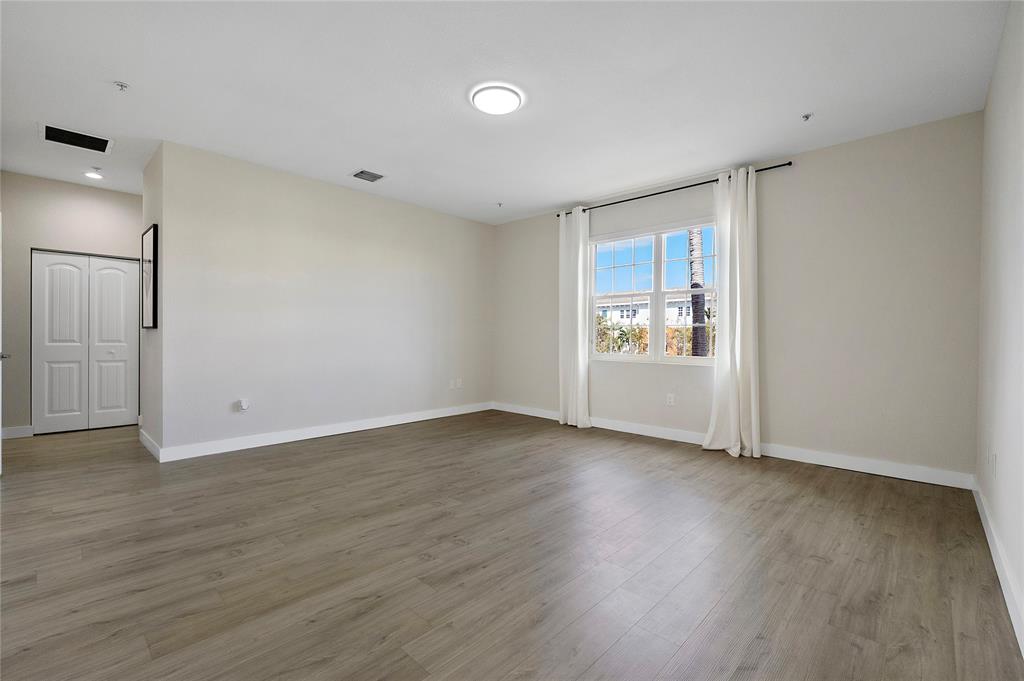 163 Southwest 7th Street Pompano Beach, FL 33060 - Photo 27 of 54 a view of an empty room with window and wooden floor
