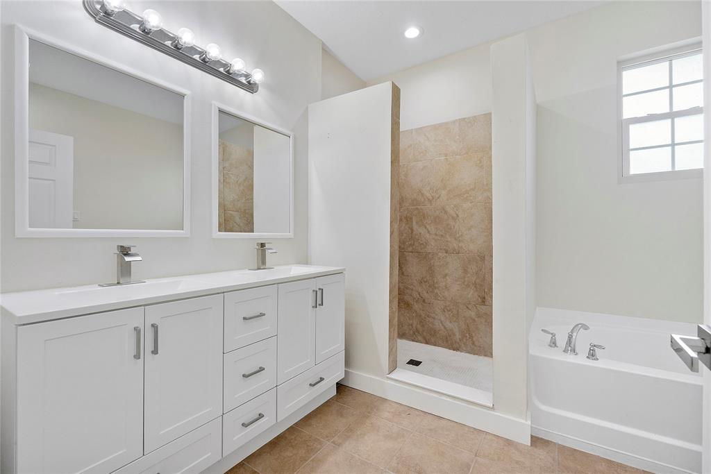 163 Southwest 7th Street Pompano Beach, FL 33060 - Photo 28 of 54 a spacious bathroom with double sink a large mirror and a bathtub