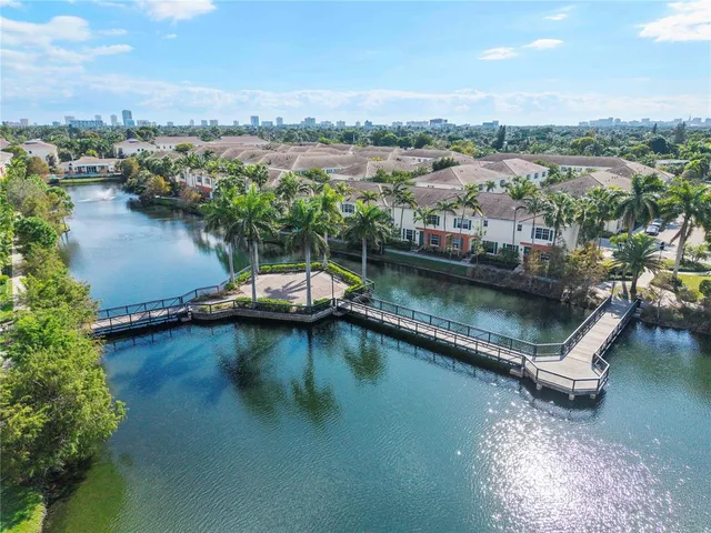 an aerial view of residential houses with outdoor space and lake view