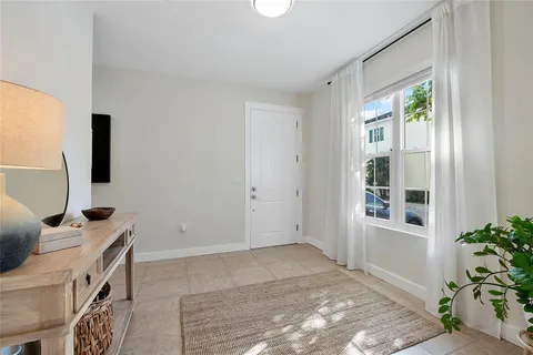a view of an empty room with furniture and a window