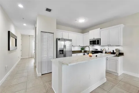 a kitchen with stainless steel appliances a sink a stove a refrigerator cabinets and a counter top space