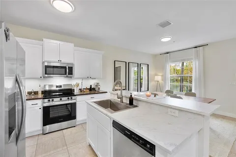 a kitchen with a sink a table and chairs