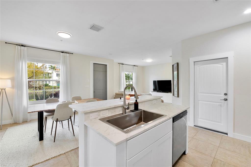163 Southwest 7th Street Pompano Beach, FL 33060 - Photo 10 of 54 a kitchen with a sink a table and chairs