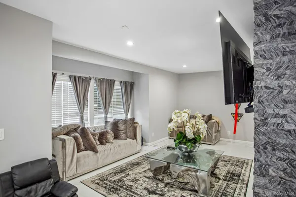 a living room with furniture flowerpot and a flat screen tv