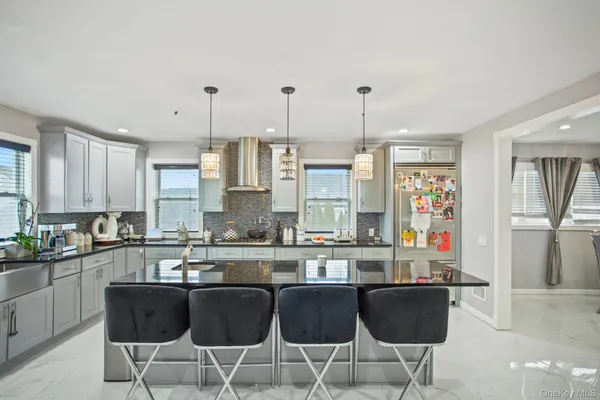 a kitchen with stainless steel appliances granite countertop a stove top oven a sink a dining table and chairs