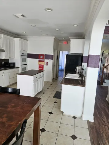 a kitchen with stainless steel appliances a stove a sink a microwave a refrigerator and cabinets