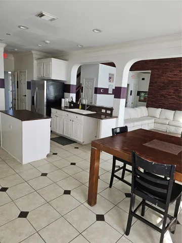 a kitchen with stainless steel appliances kitchen island granite countertop a table and chairs in it