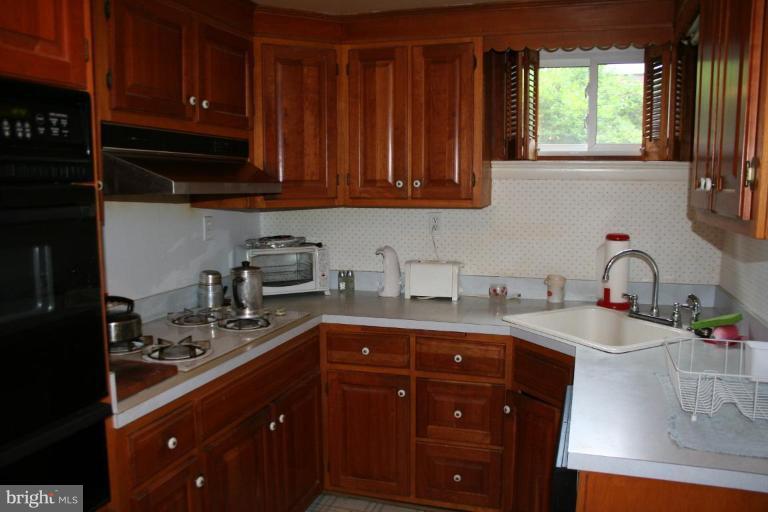 5903 Greentree Road Bethesda, MD 20817 - Photo 13 of 19 a kitchen with stainless steel appliances granite countertop a sink dishwasher stove and cabinets with wooden floor