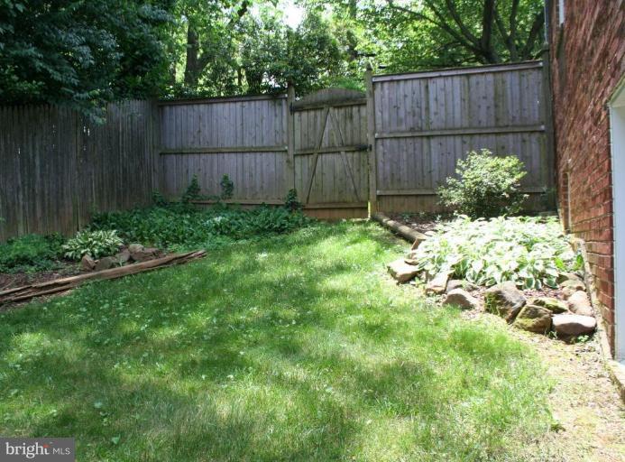 5903 Greentree Road Bethesda, MD 20817 - Photo 18 of 19 a view of a backyard with a potted plant and wooden fence