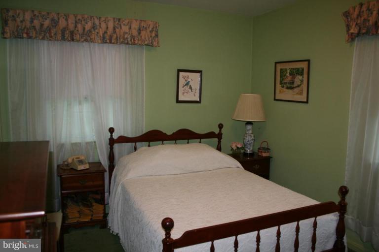 5903 Greentree Road Bethesda, MD 20817 - Photo 6 of 19 a bedroom with a bed and a table in it