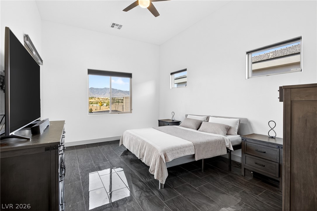 1460 Blue Ridge Trail Mesquite, NV 89027 - Photo 19 of 39 Generous ceiling heights complement the smooth tiled flooring and abundant mountain views in this primary bedroom.
