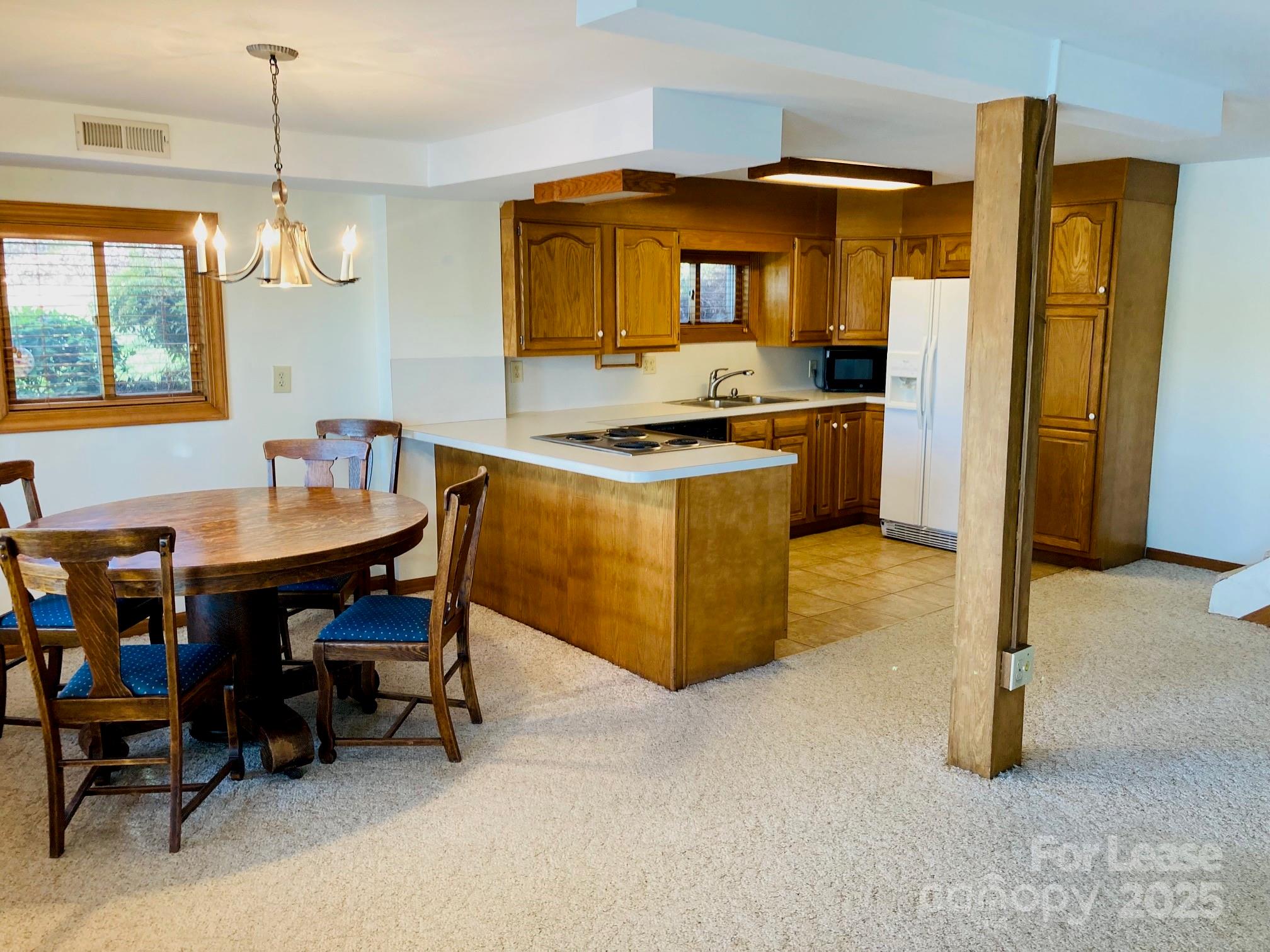 232 Hermance Lane Mooresville, NC 28117 - Photo 10 of 21 a kitchen with a table chairs refrigerator and cabinets