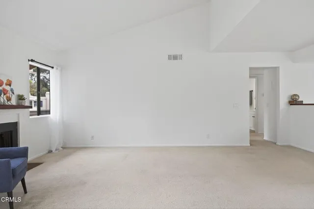 a view of a kitchen with refrigerator and white cabinets