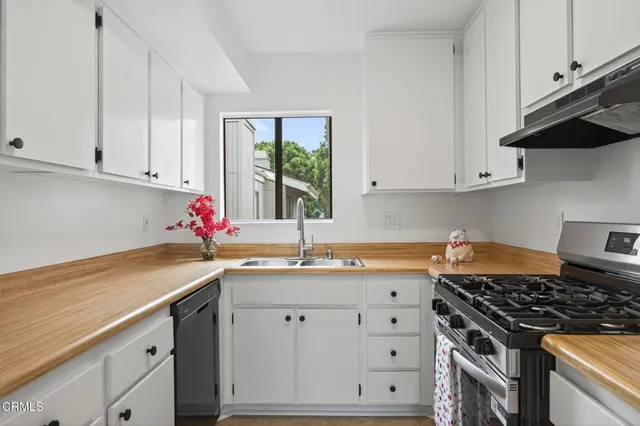 a kitchen with granite countertop a sink stove and cabinets