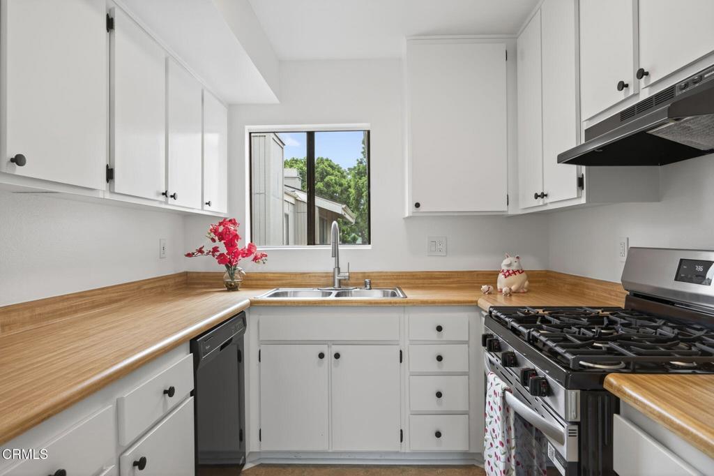 1466 San Simeon Court, Unit 2 Ventura, CA 93003 - Photo 8 of 41 a kitchen with granite countertop a sink stainless steel appliances and cabinets