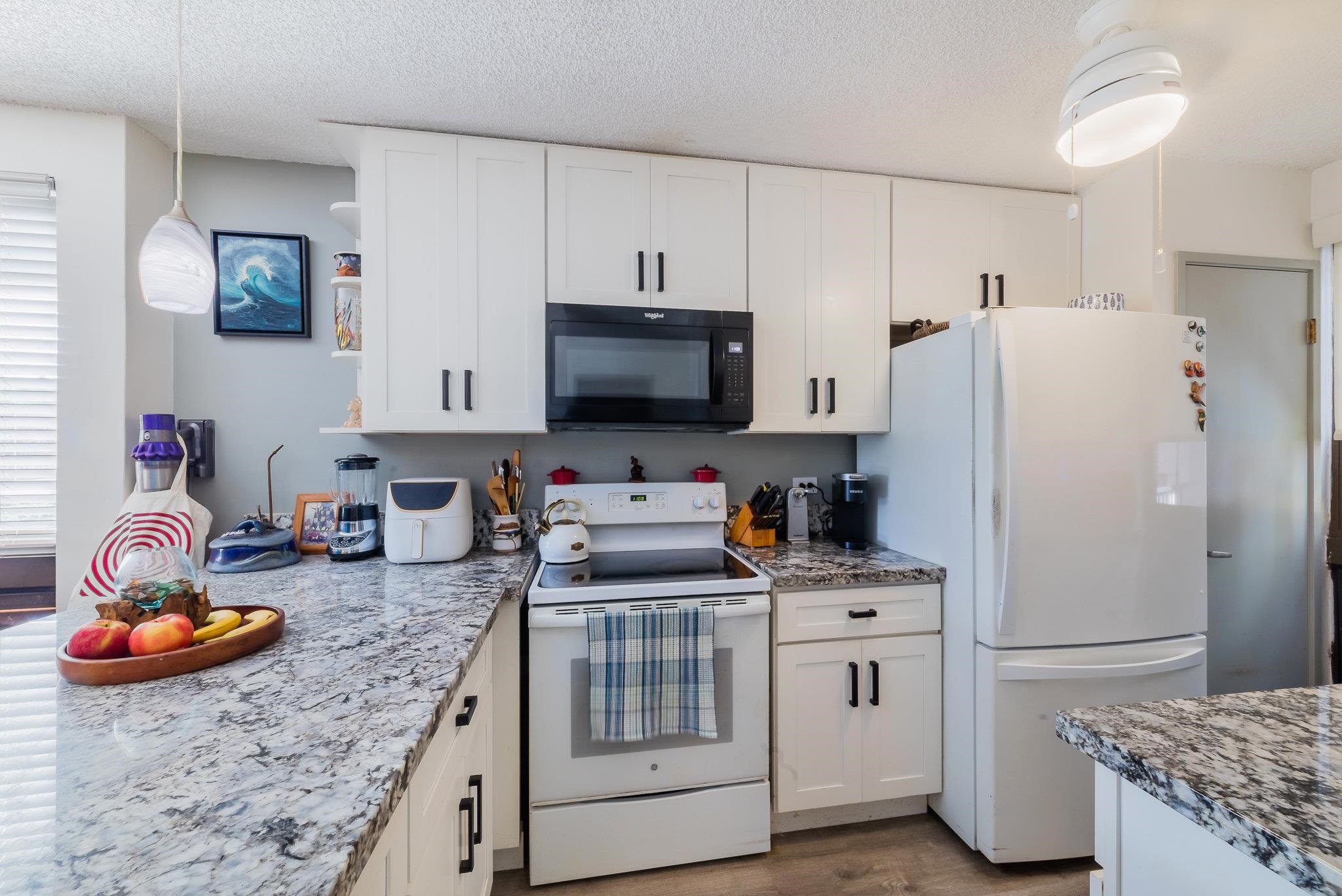 4310 Lower Honoapiilani Road, Unit 419 Lahaina, HI 96761 - Photo 2 of 32 a kitchen with stainless steel appliances a stove refrigerator sink and microwave
