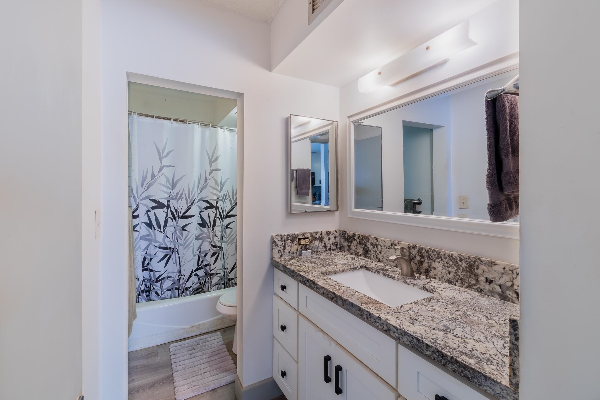 4310 Lower Honoapiilani Road, Unit 419 Lahaina, HI 96761 - Photo 22 of 32 a bathroom with a granite countertop sink and a mirror