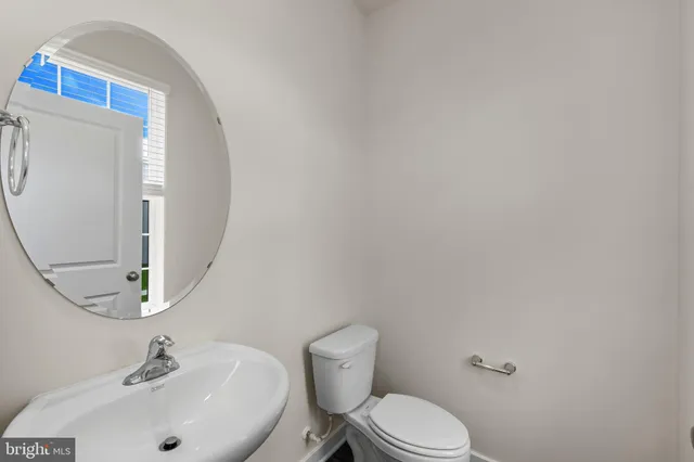 a bathroom with a sink mirror and toilet