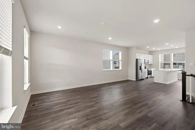 a view of empty room with wooden floor and windows