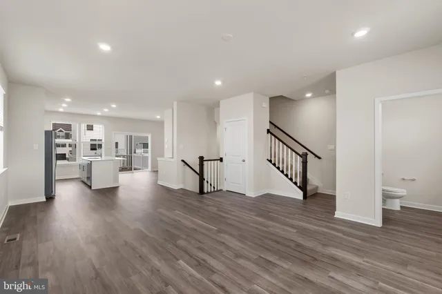 a view of an empty room with wooden floor and a potted plant