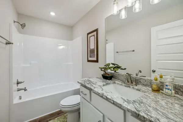 a bathroom with a granite countertop sink a large mirror and a shower