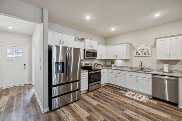 a kitchen with stainless steel appliances granite countertop a stove a sink dishwasher and a refrigerator